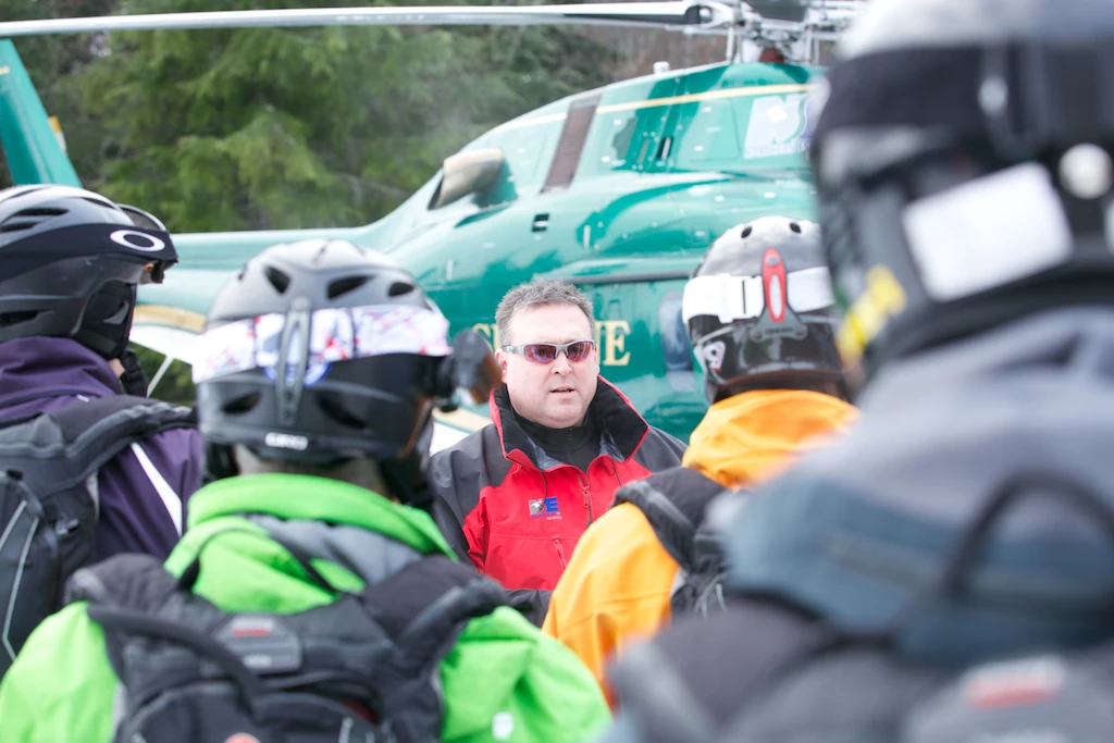 John Forrest briefing a group of guests before boarding the helicopter at Northern Escape Heli-Skiing.