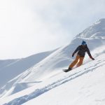 Heli snowboarding on a sunny day.