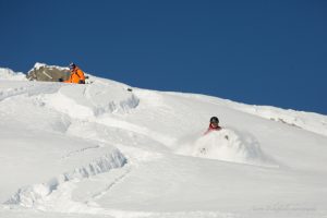 Heli skiing in neck deep powder.